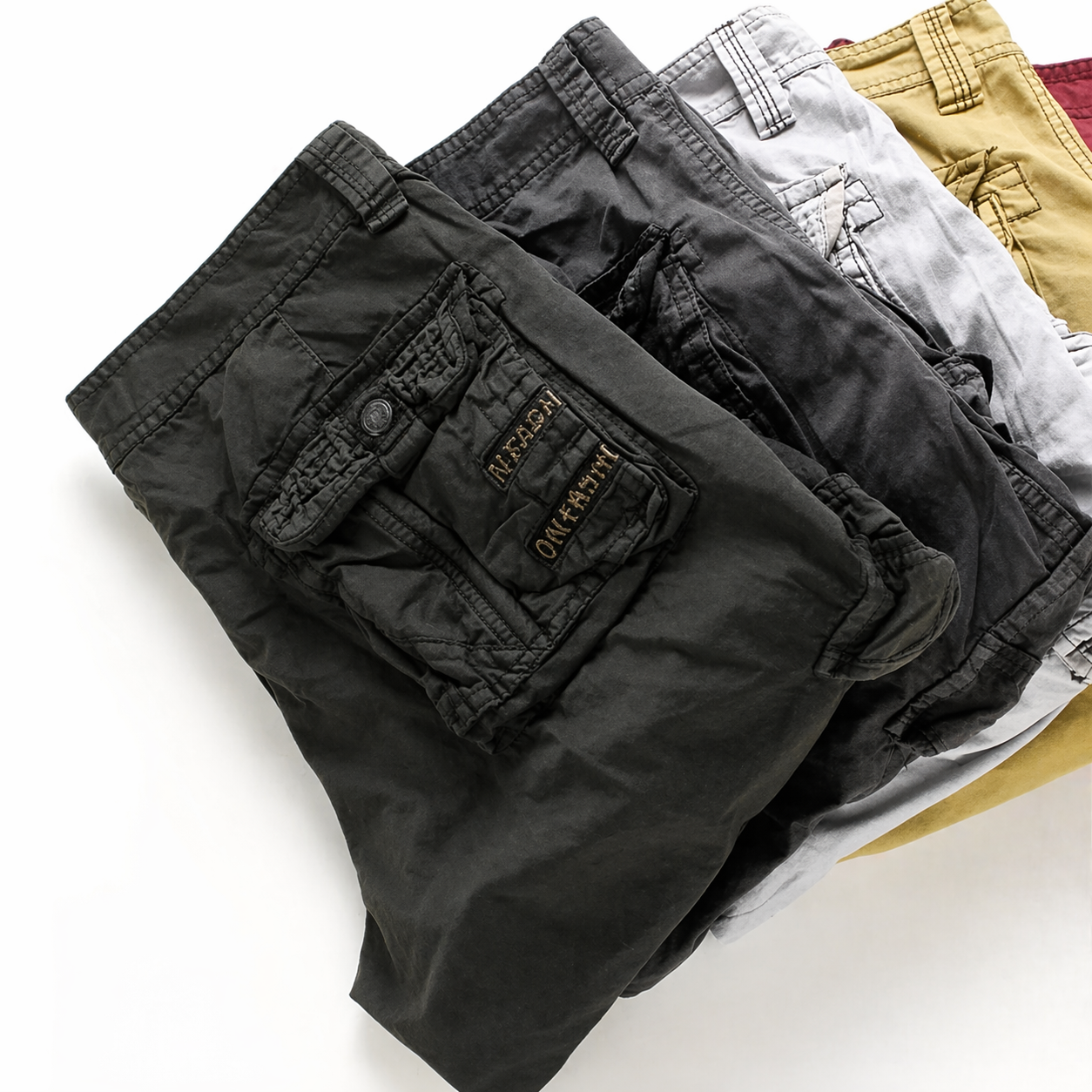 Folded black cargo shorts with a brand logo on a white background