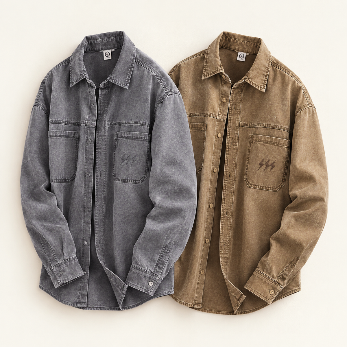 Two long-sleeve button-front overshirts laid flat on a light warm background. The left shirt is washed charcoal gray, and the right shirt is tan/khaki brown.
