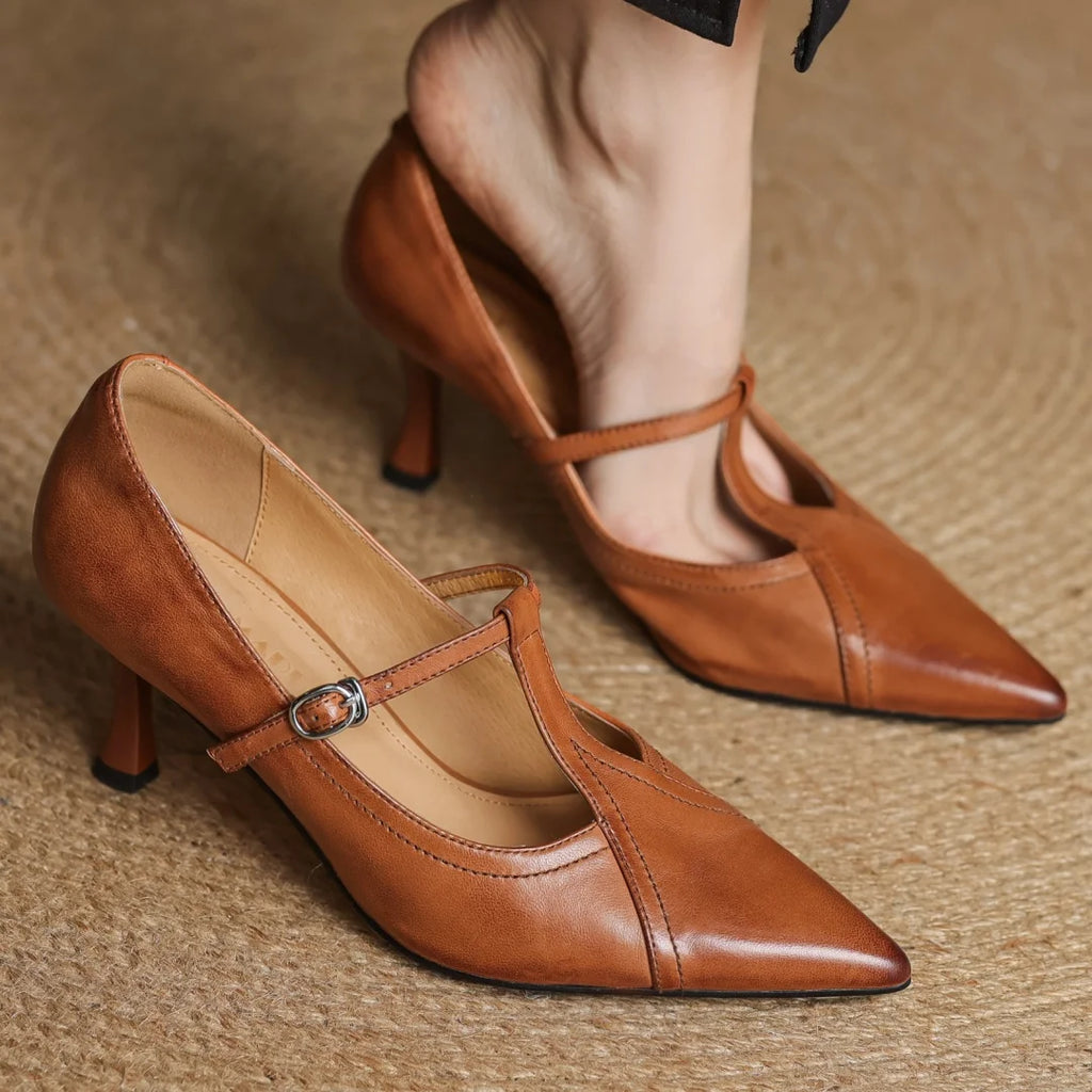Brown leather shoes with a strap on a textured surface
