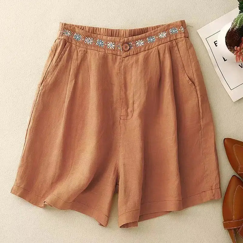 Brown shorts with floral waistband on a light surface